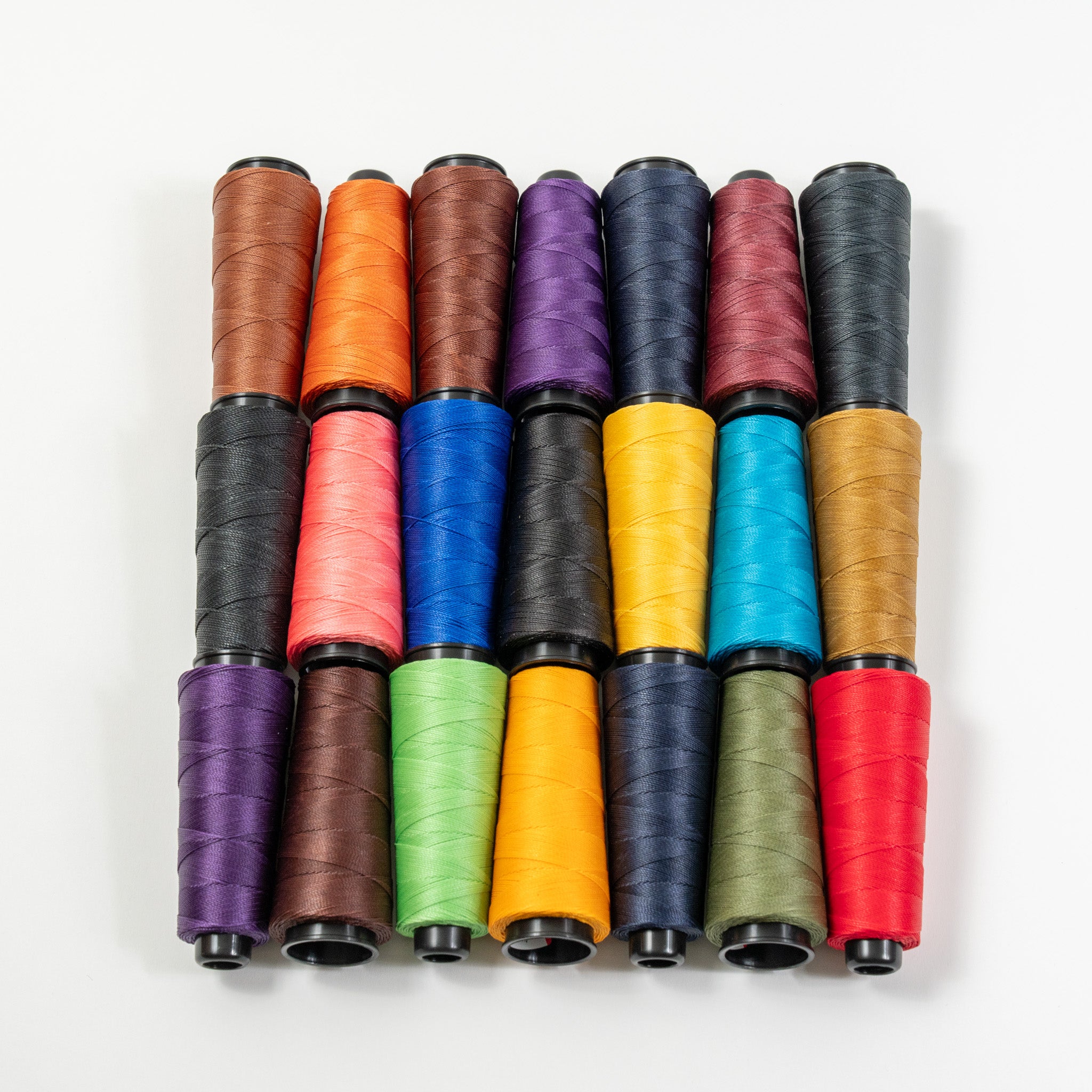 Top view of MBT waxed polyester thread spools in assorted colors