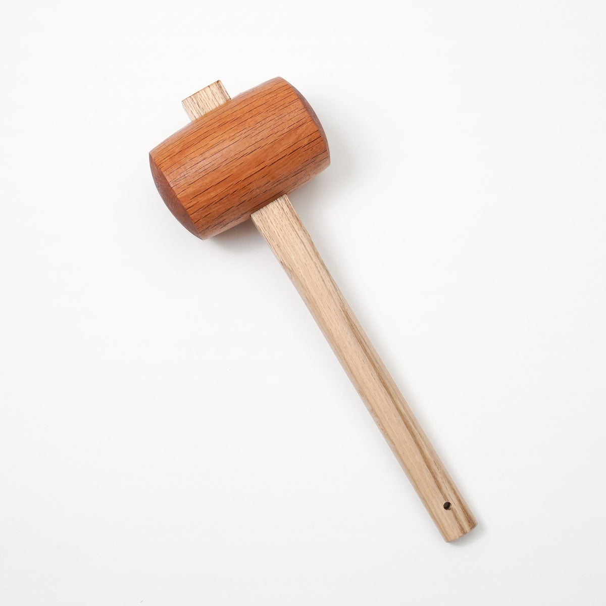 A wooden mallet tool with a reddish-brown head and a light natural wood handle, photographed on a clean white background.