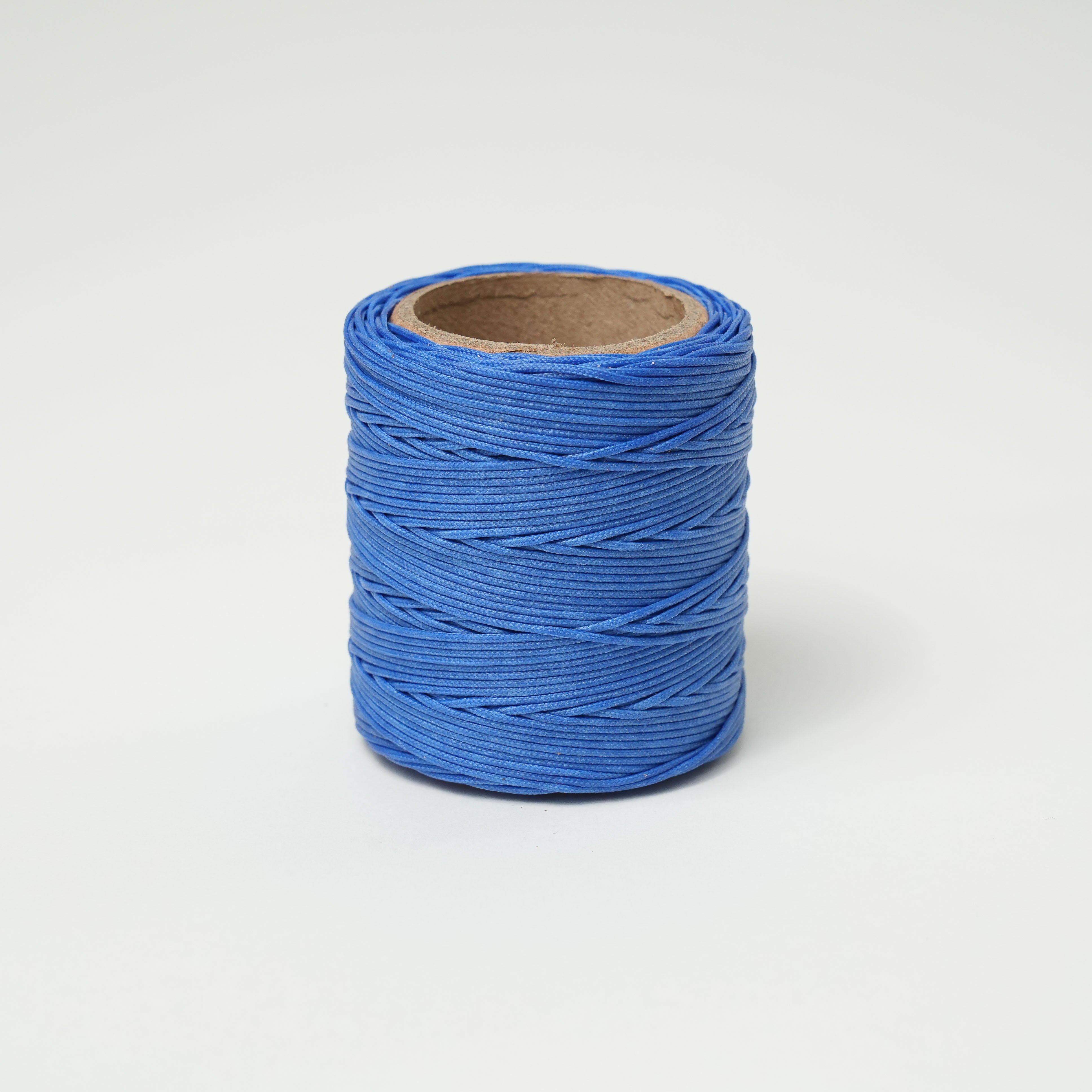Roll of blue thread on a white background