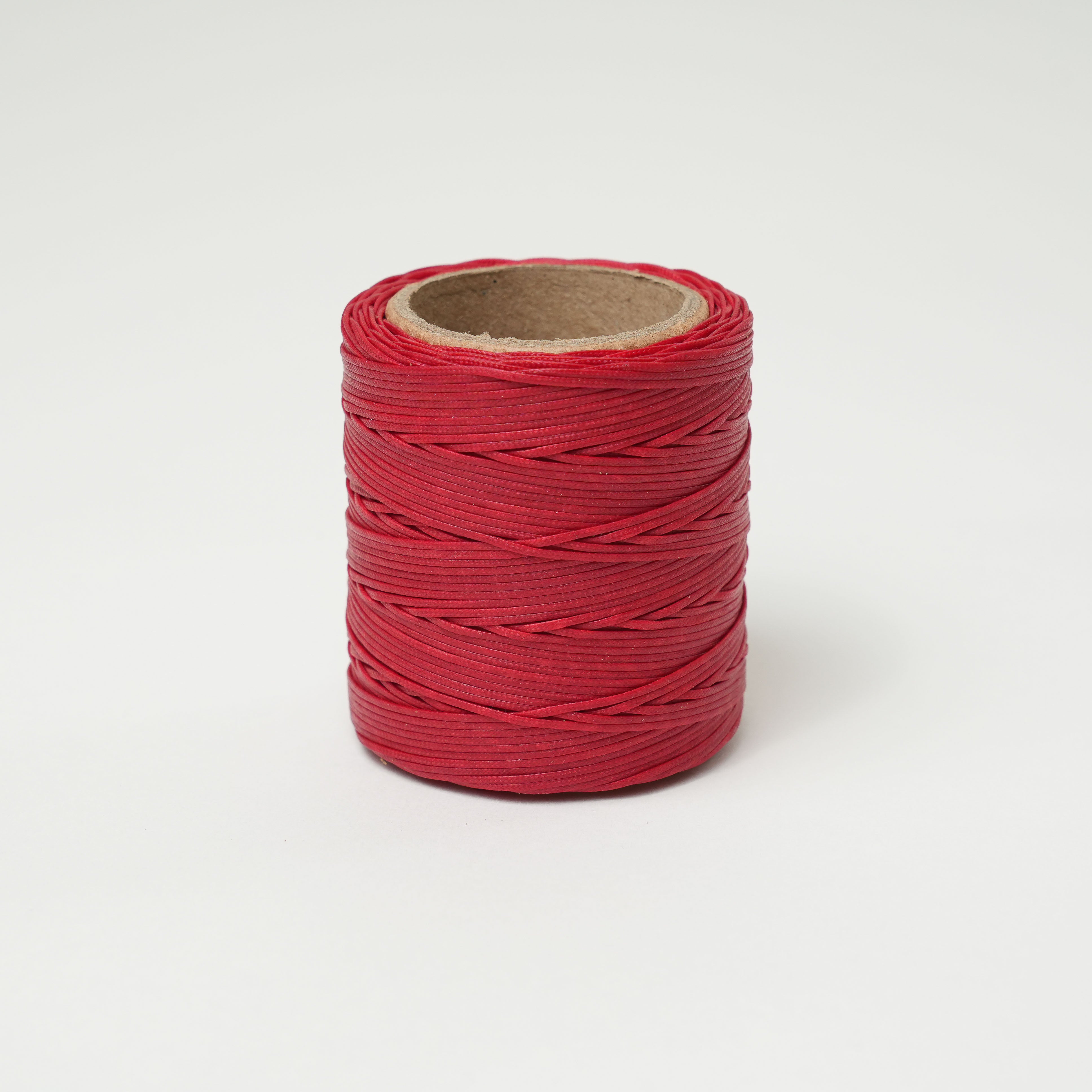 crimson red spool of thread on a white background