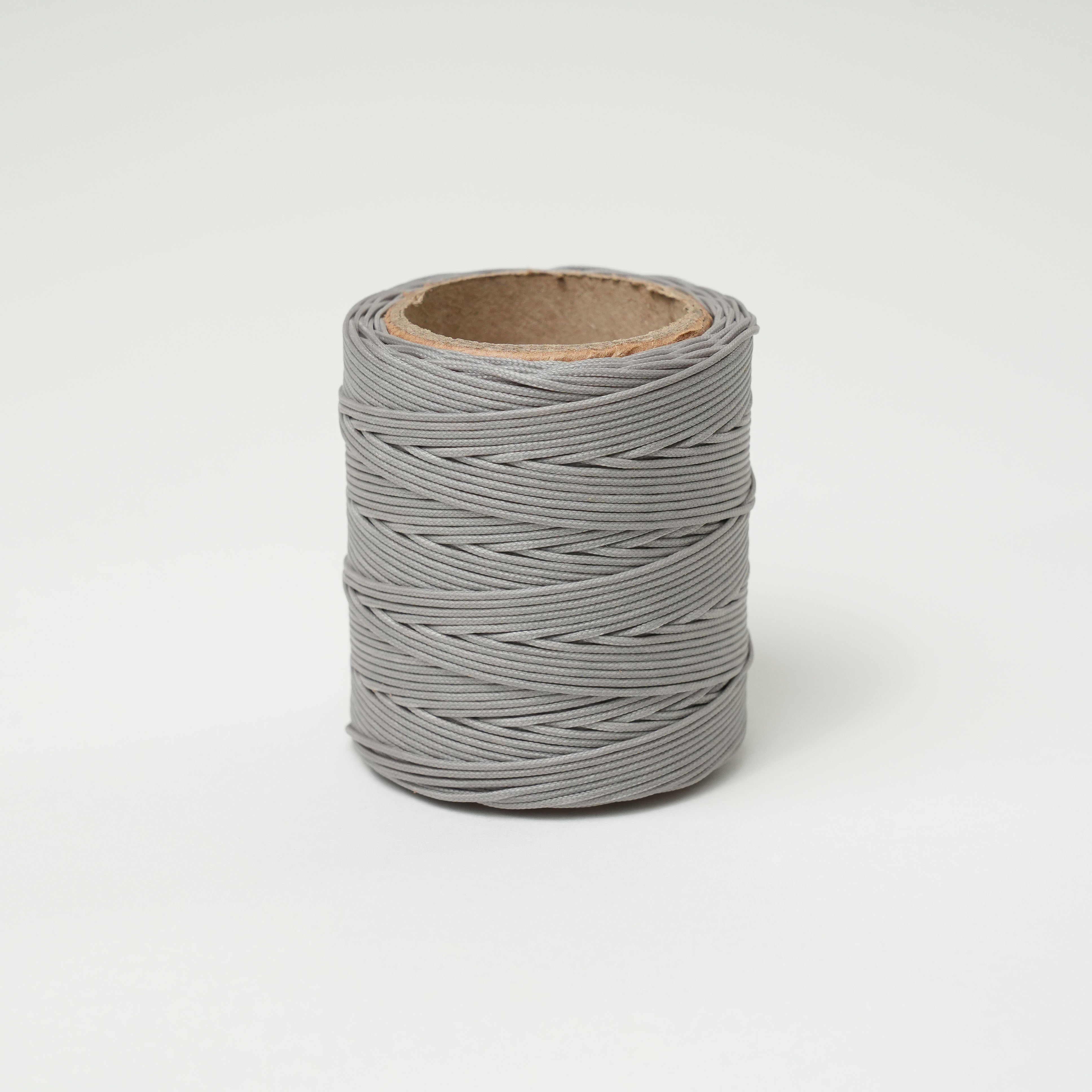 Spool of granite gray thread on a white background