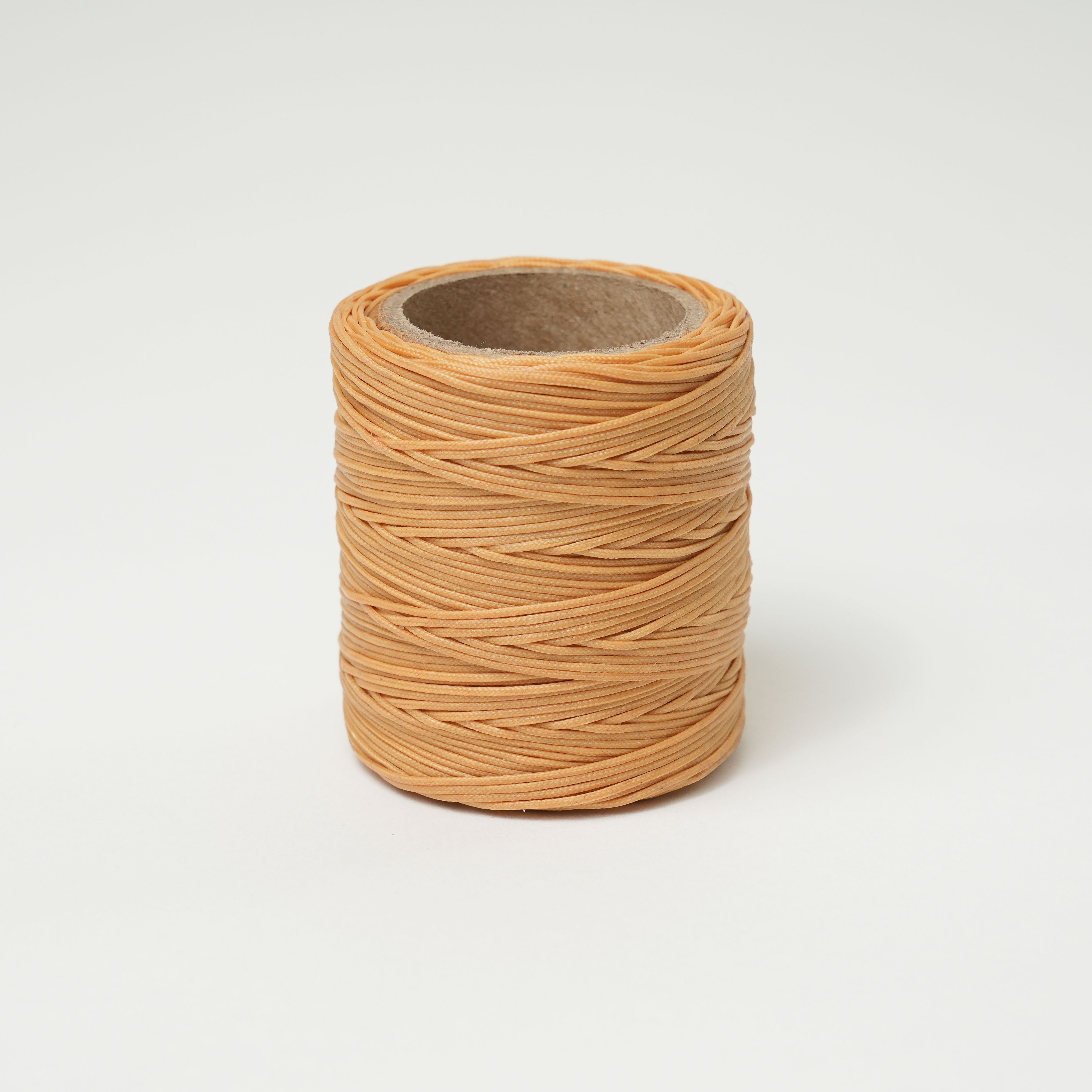 Roll of Ochre thread on a white background