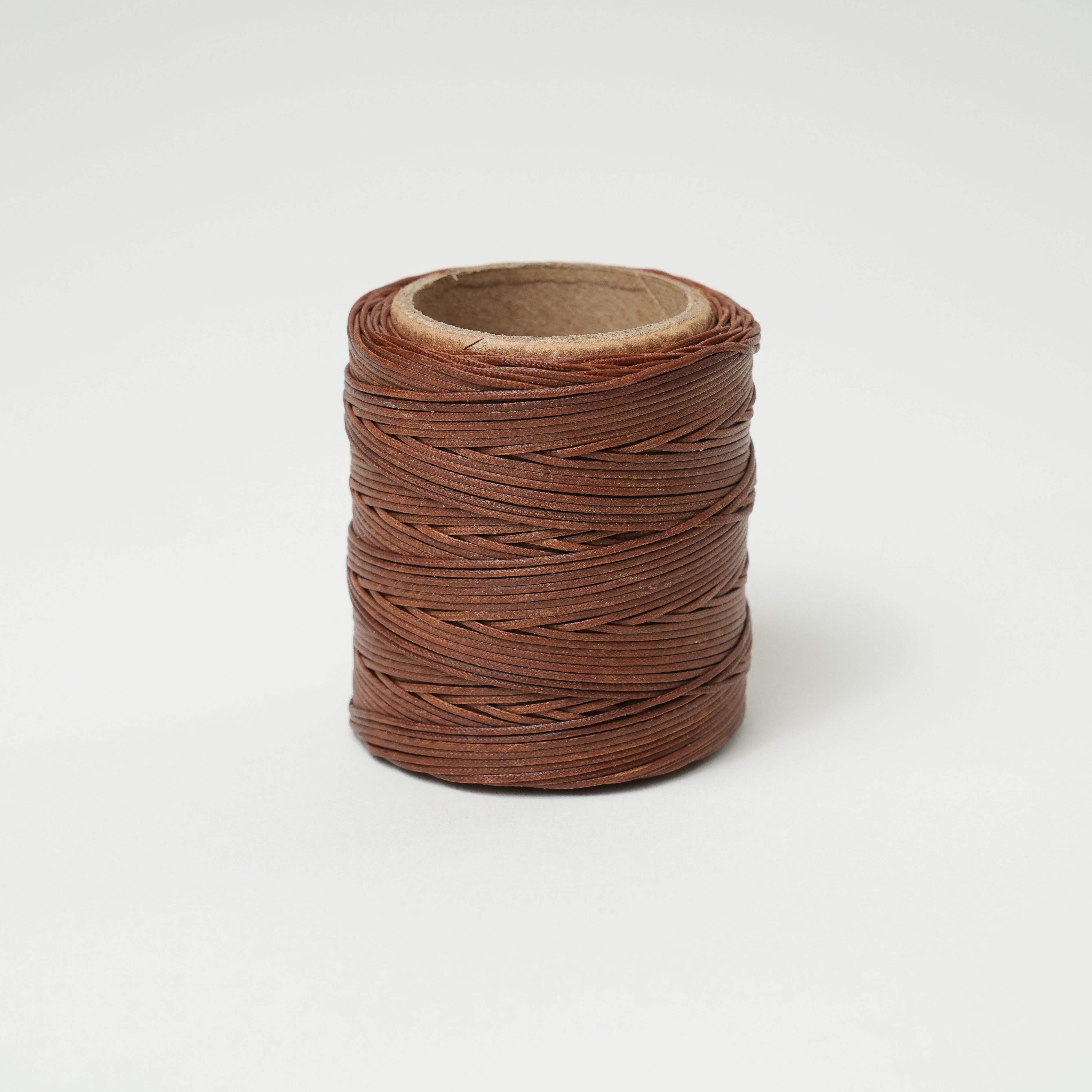 Spool of russet thread on a white background